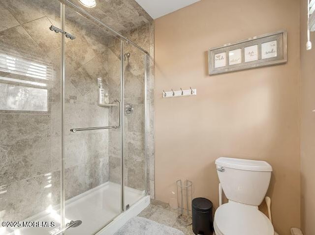 bathroom featuring an enclosed shower and toilet