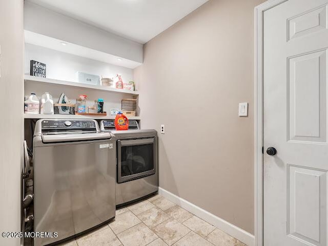 clothes washing area featuring light tile patterned floors and washing machine and clothes dryer