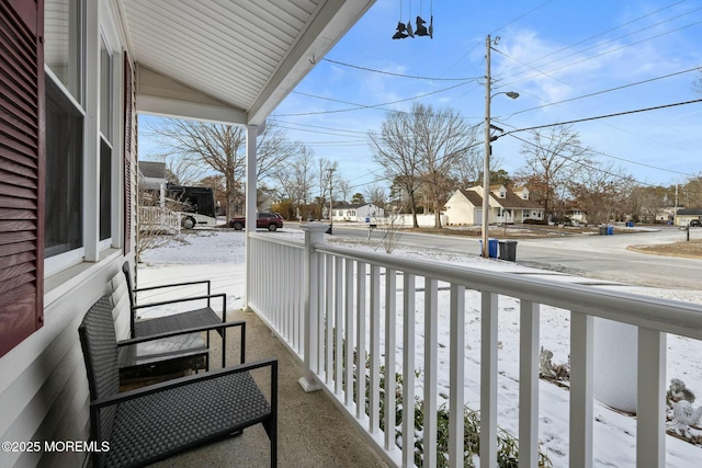 view of snow covered back of property