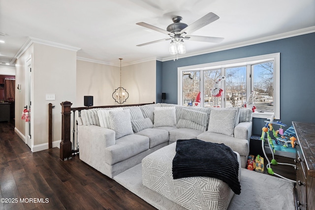 living room with dark wood-type flooring, crown molding, and ceiling fan with notable chandelier