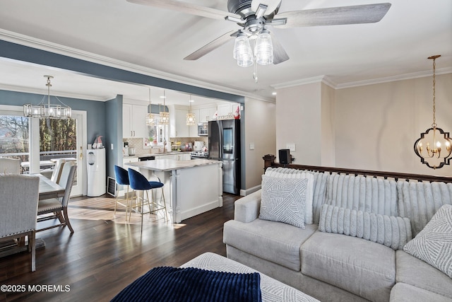 living room with sink, ceiling fan with notable chandelier, wood-type flooring, and ornamental molding