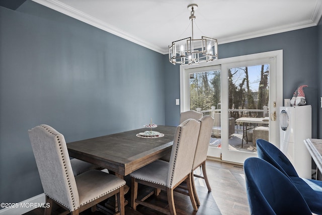 dining space featuring hardwood / wood-style flooring, ornamental molding, and an inviting chandelier