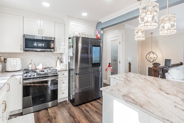 kitchen featuring stainless steel appliances, decorative light fixtures, and white cabinets