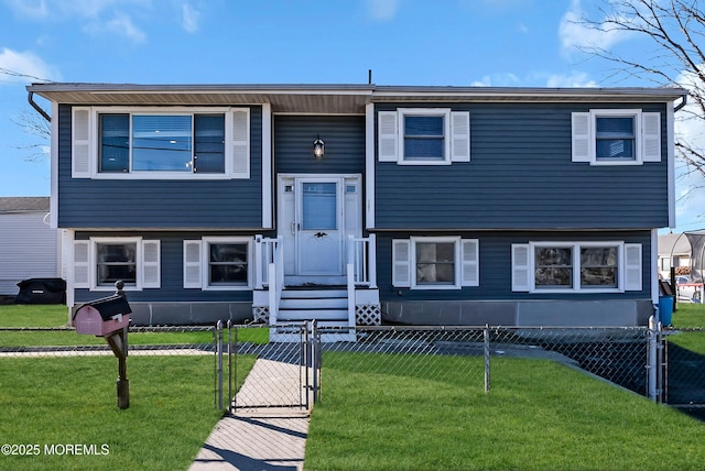 bi-level home with a fenced front yard, a front lawn, and a gate