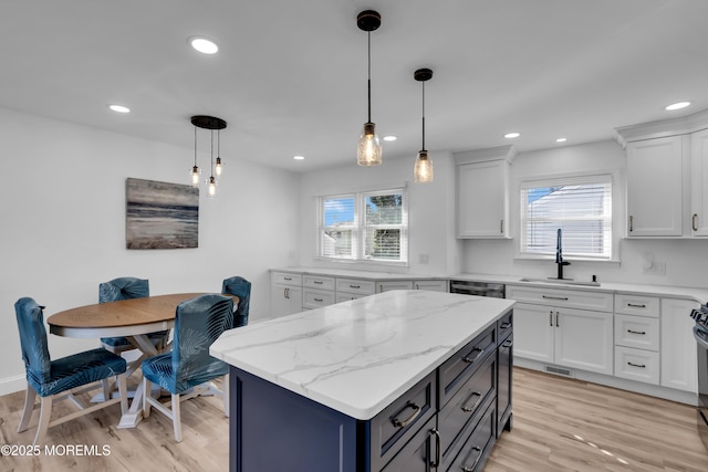 kitchen with pendant lighting, light wood-type flooring, recessed lighting, white cabinetry, and a sink