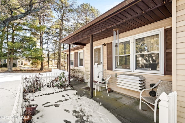 snow covered patio featuring covered porch