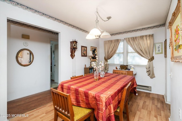 dining area featuring baseboard heating and hardwood / wood-style floors