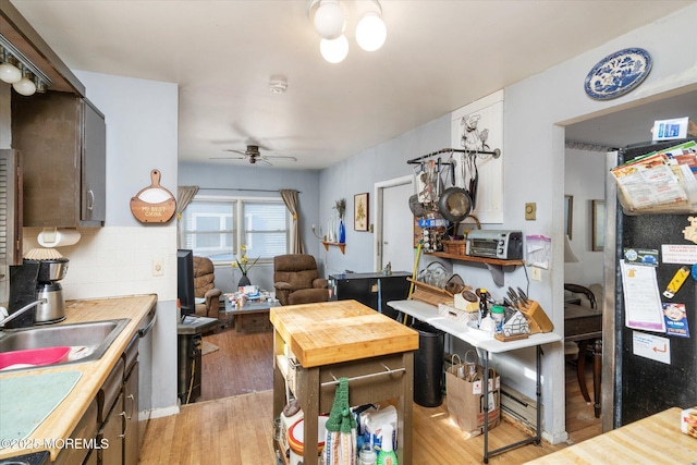 kitchen with tasteful backsplash, sink, hardwood / wood-style floors, and ceiling fan