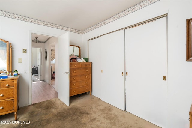 bedroom featuring light colored carpet and a closet