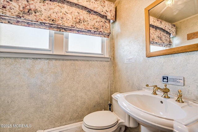 bathroom with a baseboard radiator, sink, and toilet