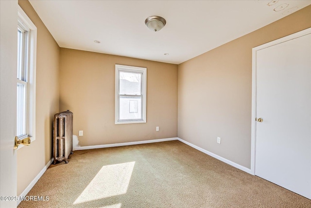 unfurnished room with radiator and carpet floors