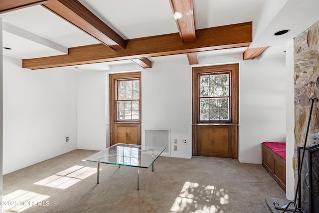 carpeted entryway featuring plenty of natural light and beam ceiling