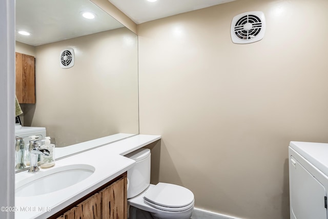 bathroom with vanity, toilet, and washing machine and clothes dryer