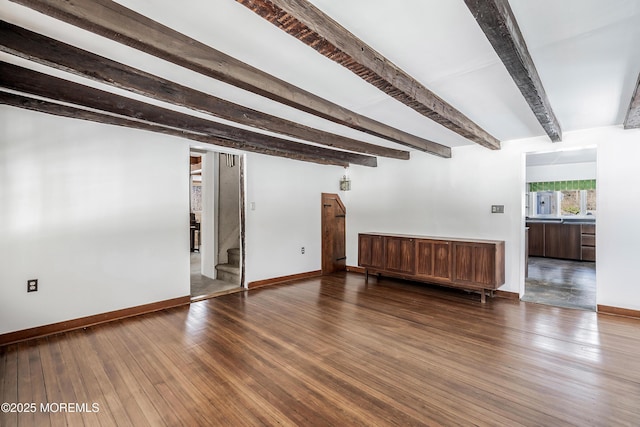 spare room with dark hardwood / wood-style floors and beam ceiling