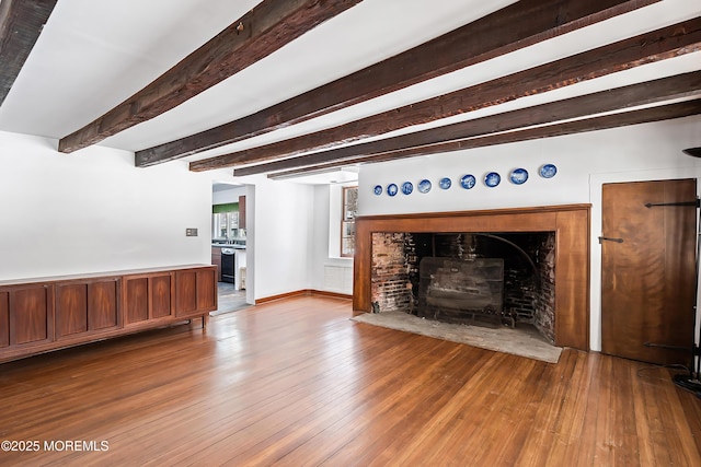 unfurnished living room with beamed ceiling and hardwood / wood-style floors