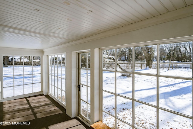 unfurnished sunroom featuring wood ceiling and plenty of natural light