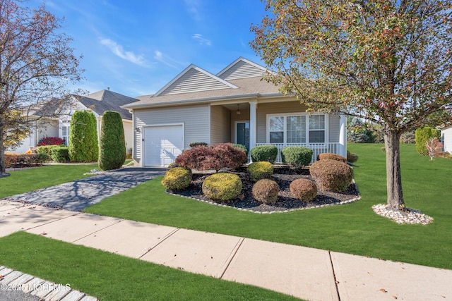 view of front of property with a garage, covered porch, and a front yard