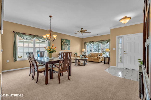 carpeted dining area featuring ornamental molding and ceiling fan with notable chandelier