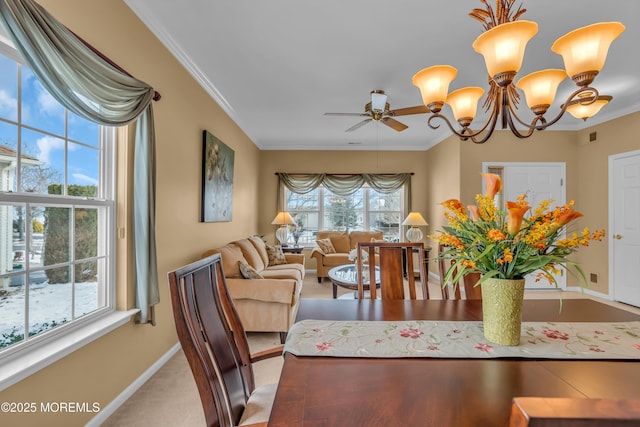 dining space with crown molding, a healthy amount of sunlight, and ceiling fan with notable chandelier