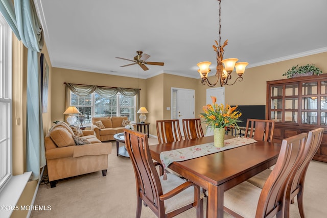 dining room featuring crown molding, ceiling fan with notable chandelier, and light carpet