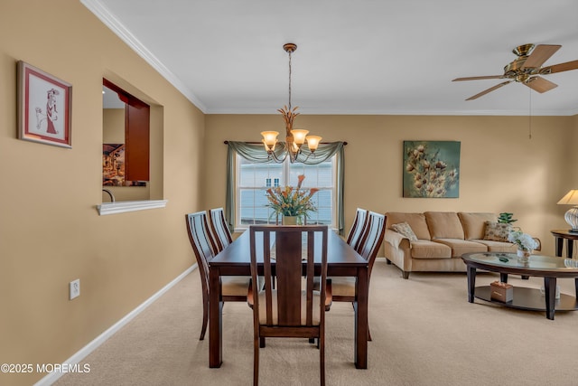 dining room featuring crown molding, ceiling fan with notable chandelier, and light carpet