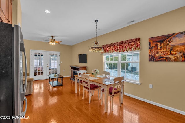 dining room with ceiling fan, light hardwood / wood-style floors, and french doors