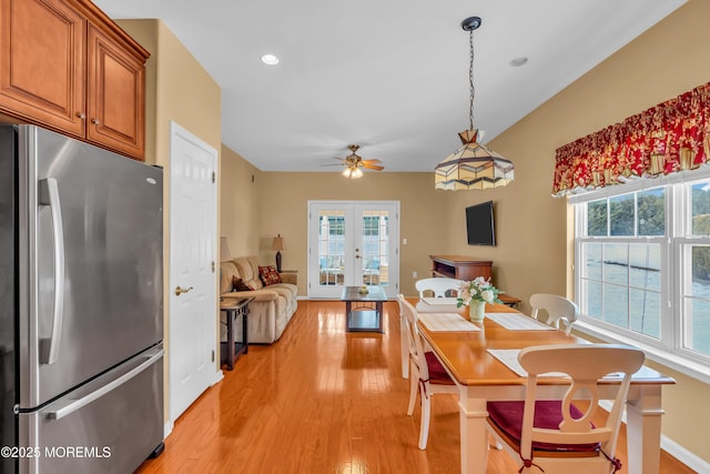 dining space featuring french doors, ceiling fan, and light hardwood / wood-style flooring