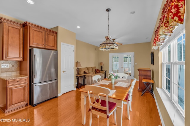 dining area featuring light wood-type flooring and french doors