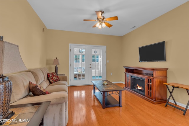 living room with hardwood / wood-style flooring, french doors, and ceiling fan