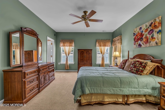 carpeted bedroom with ceiling fan and multiple windows