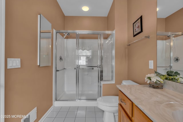 bathroom featuring vanity, a shower with shower door, tile patterned floors, and toilet