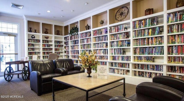 living area with crown molding, carpet, and built in shelves