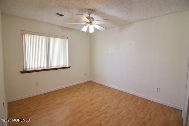 spare room with ceiling fan, a textured ceiling, and light wood-type flooring