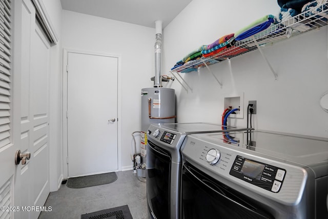 clothes washing area with separate washer and dryer and water heater