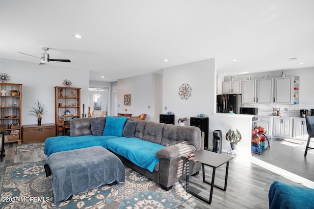 living room featuring light hardwood / wood-style floors and ceiling fan