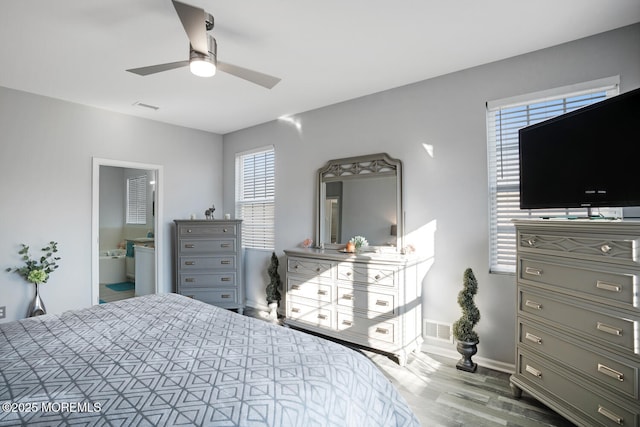 bedroom featuring connected bathroom, hardwood / wood-style floors, and ceiling fan