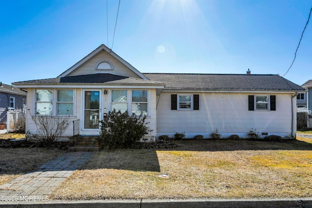 view of front facade with roof with shingles, a front lawn, and crawl space