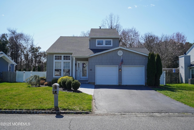 view of property featuring a garage and a front lawn