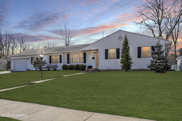 ranch-style house with a garage and a lawn