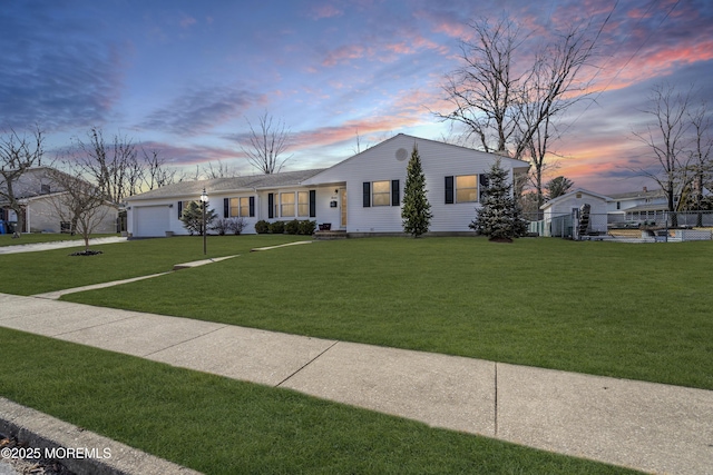 view of front of property featuring a garage and a lawn