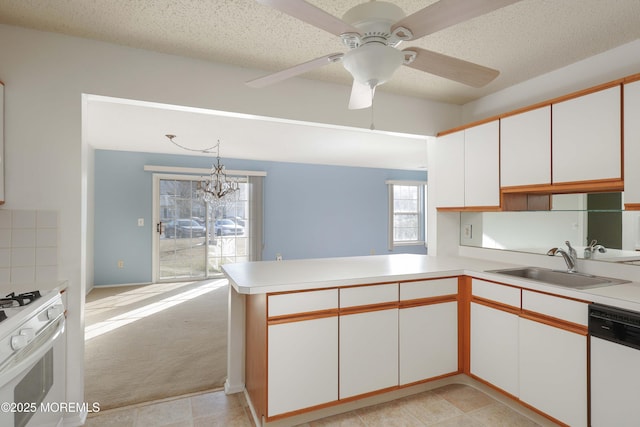 kitchen featuring sink, decorative light fixtures, kitchen peninsula, white appliances, and white cabinets