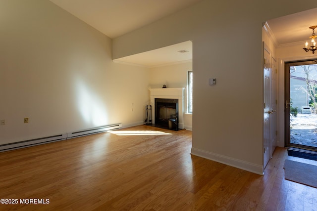 interior space with wood-type flooring, a baseboard heating unit, crown molding, and a chandelier