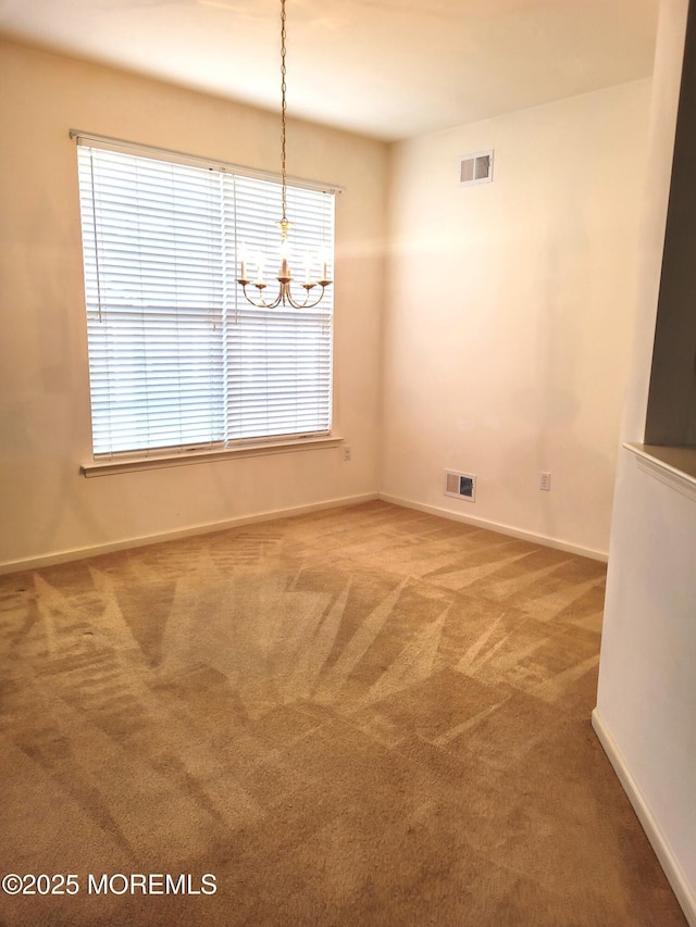 unfurnished dining area featuring a healthy amount of sunlight, carpet floors, and an inviting chandelier