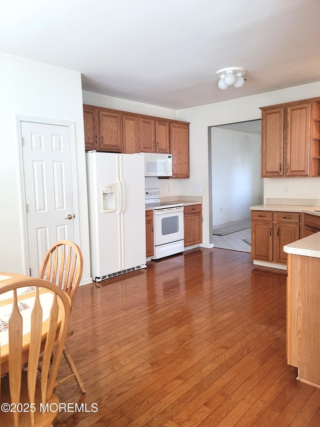 kitchen with dark wood-type flooring and white appliances