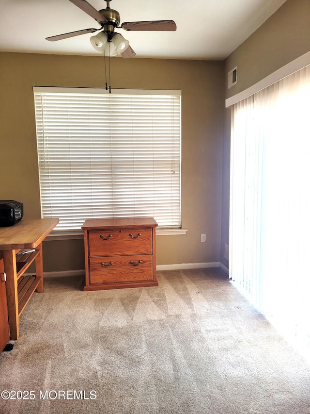 interior space with light carpet and ceiling fan