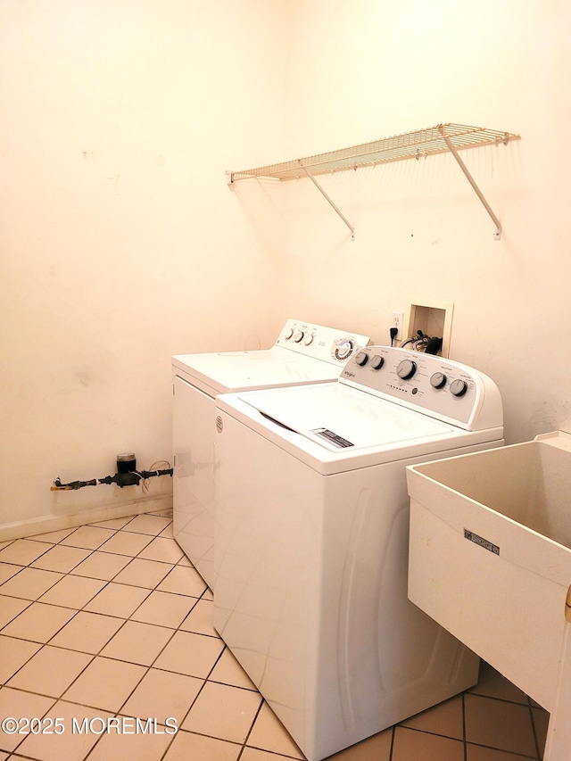 clothes washing area featuring independent washer and dryer, sink, and light tile patterned floors