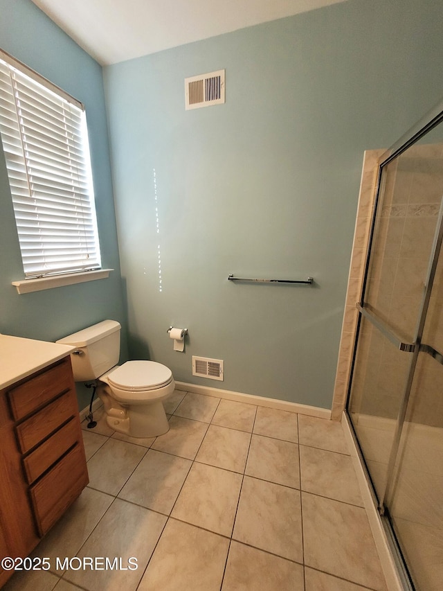 bathroom featuring walk in shower, tile patterned floors, toilet, and vanity