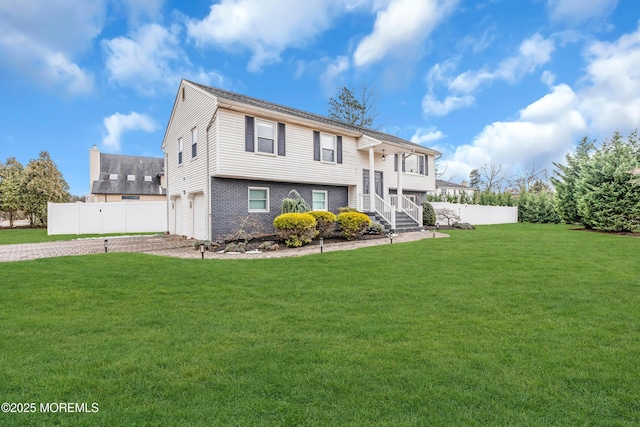 bi-level home with a garage and a front yard