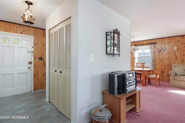 entryway featuring an inviting chandelier and wooden walls