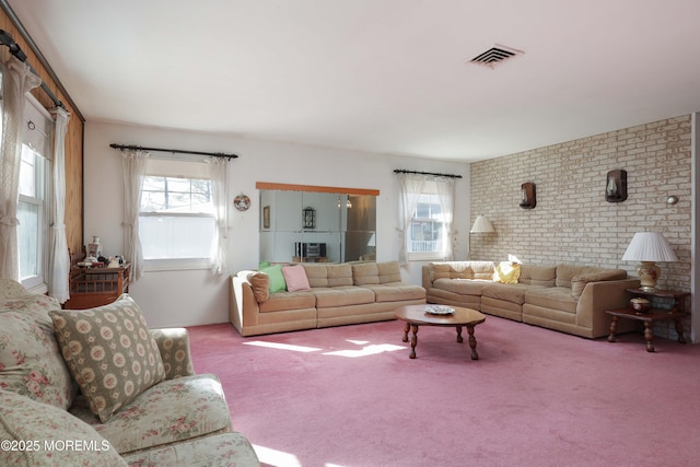 living room with carpet floors and brick wall